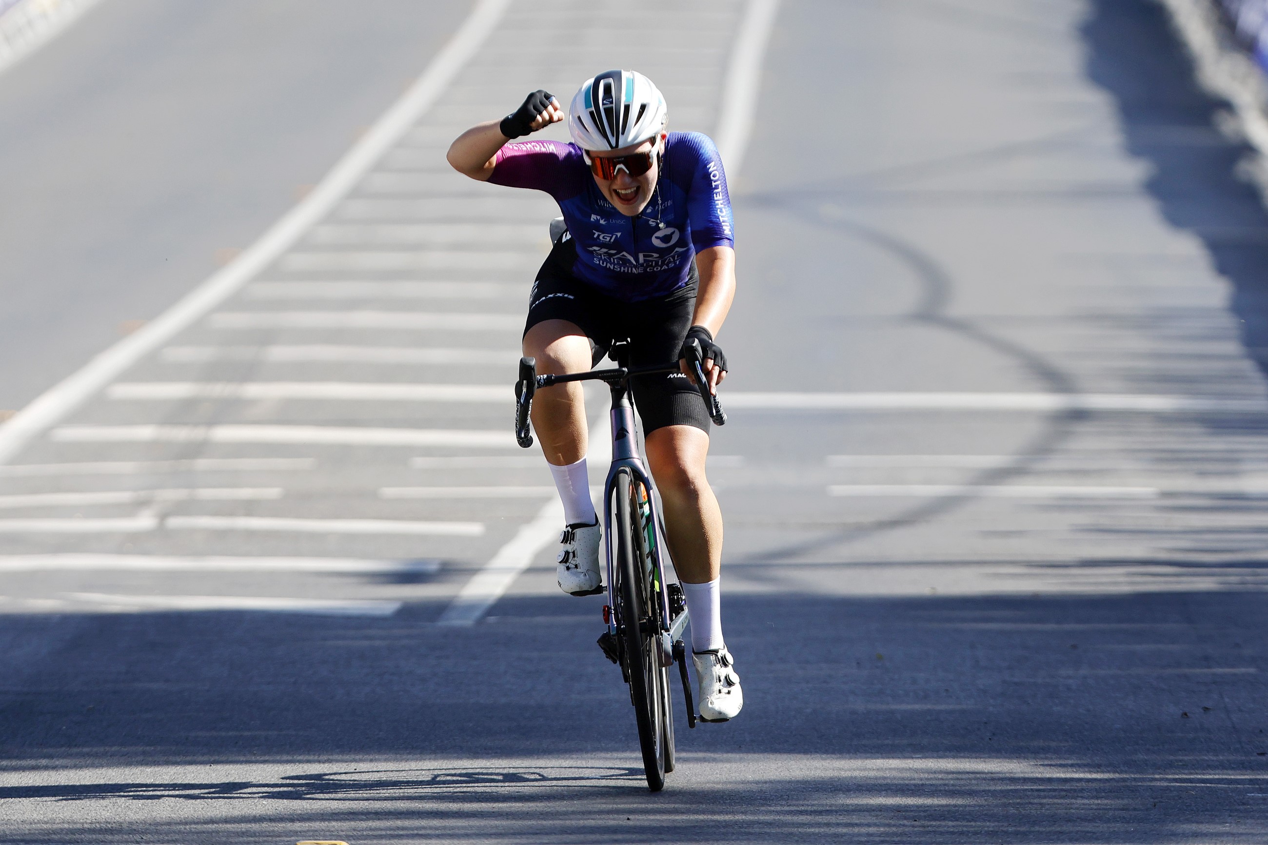  Lauren Bates punches the air as she wins the junior women's 2024 road race national championship in Ballarat